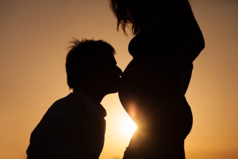 Man kissing pregnant woman's belly