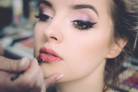 Woman applying makeup to face