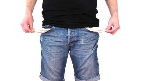 Person with no money showing empty pockets