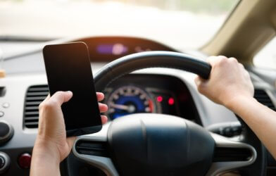 Distracted driving: person using phone behind wheel