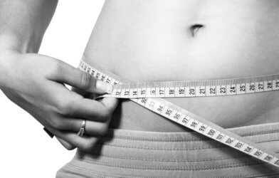 Woman measuring body fat or waist size