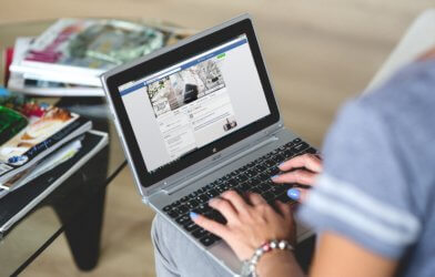 Woman looking at Facebook on laptop