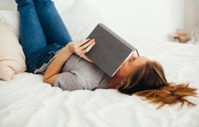 Woman reading alone in bed