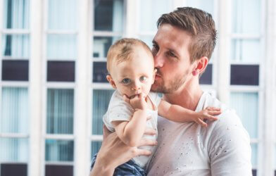 Dad kissing young child