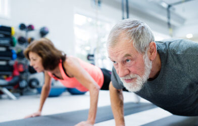 Older adults working out in the gym doing pushups