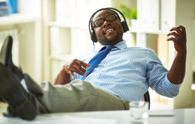 Man listening to music, getting distracted at work
