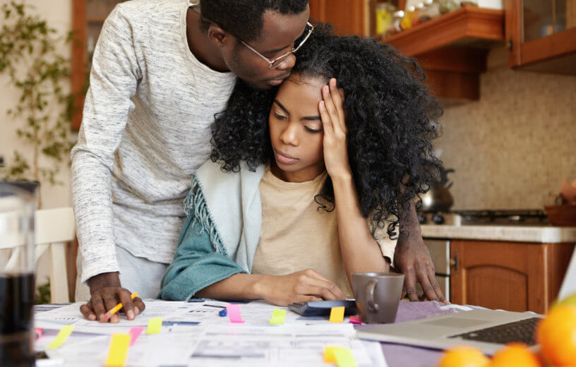 Couple experiencing financial stress while reviewing bills