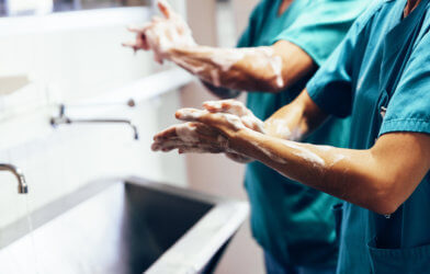 Doctors washing their hands in hospital sink