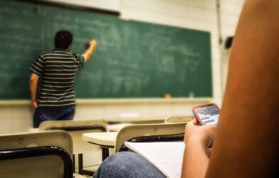 Student looking at phone while in classroom