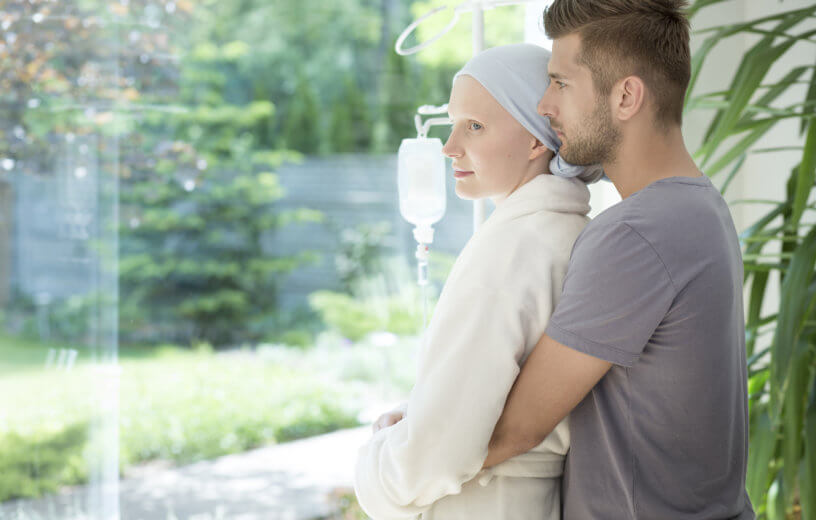 Man hugging sick girlfriend or wife with breast cancer during treatment