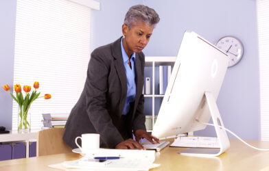 Older Black woman working at desk in office