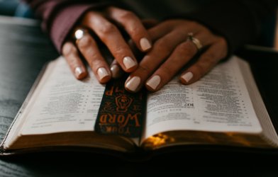 Woman's hands atop the Bible
