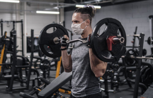 Man working out at gym with face mask on during COVID pandemic