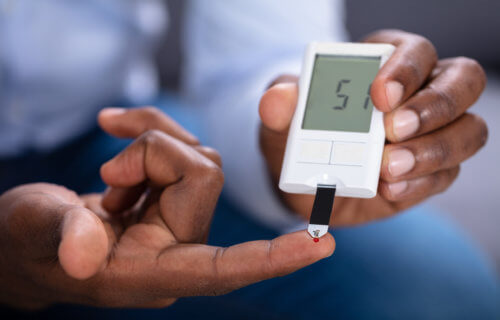Man With Diabetes Checking Blood Sugar Level With Glucometer