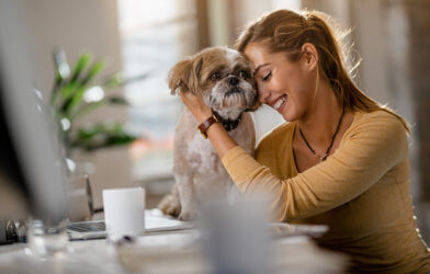 Woman hugging dog in office
