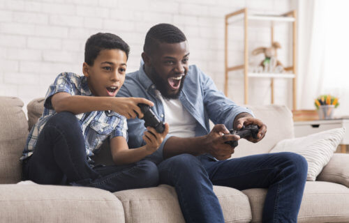 Father, son playing video games together