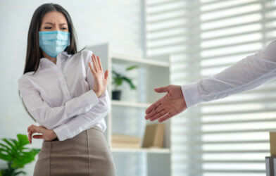Woman in mask won't shake hand during COVID pandemic