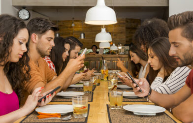 People staring at phone screens at dinner
