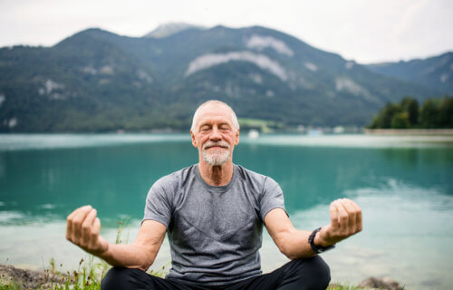 Senior, older man doing yoga or mindfulness meditation