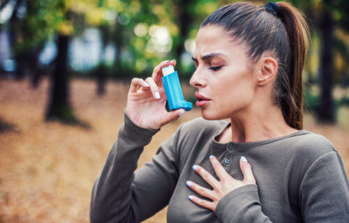Woman with asthma using inhaler